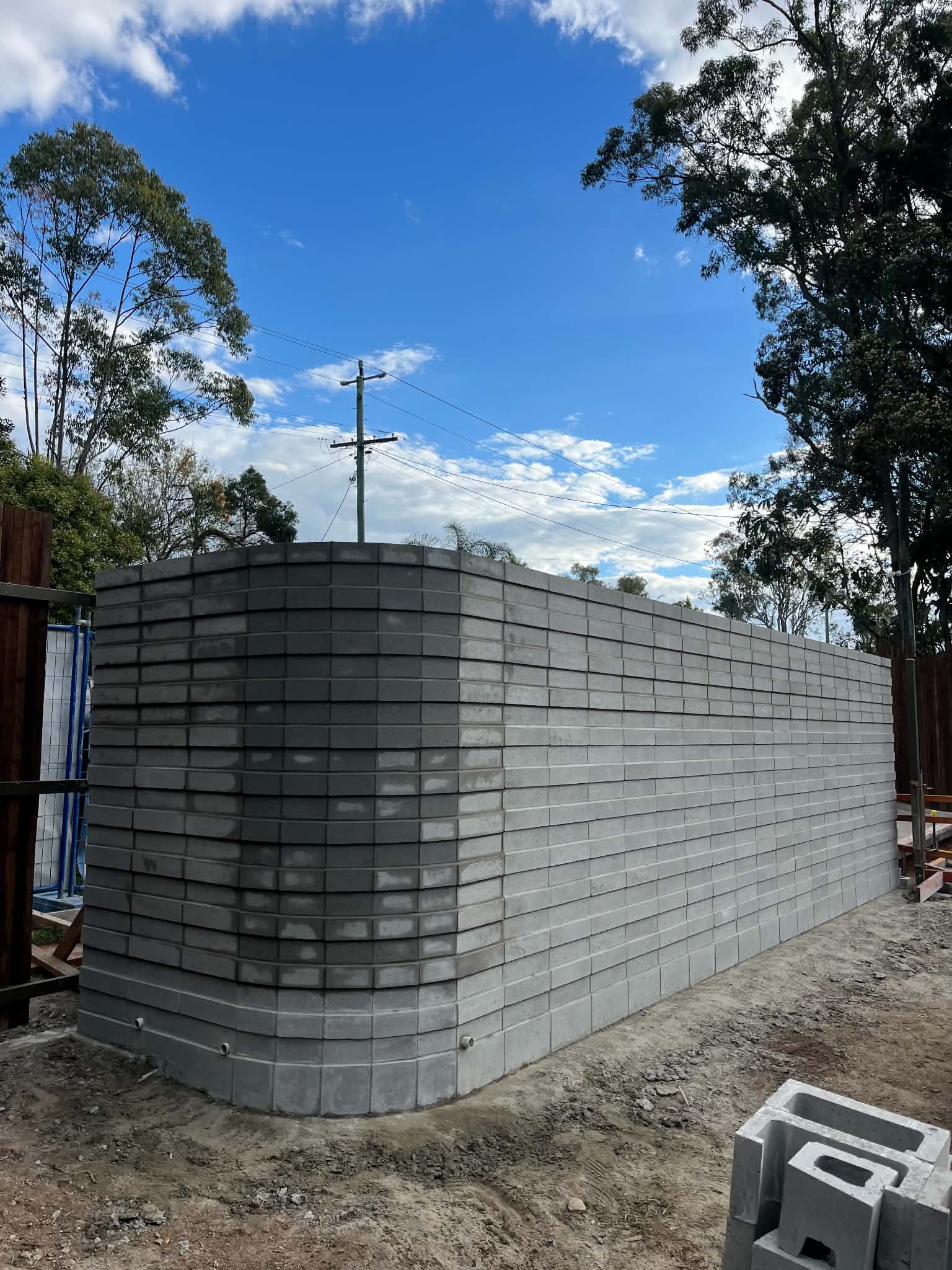Grey block retaining wall with rounded corner during construction