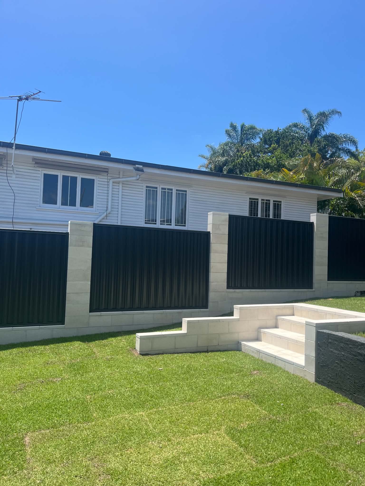 Light block garden steps beside retaining wall and dark fence