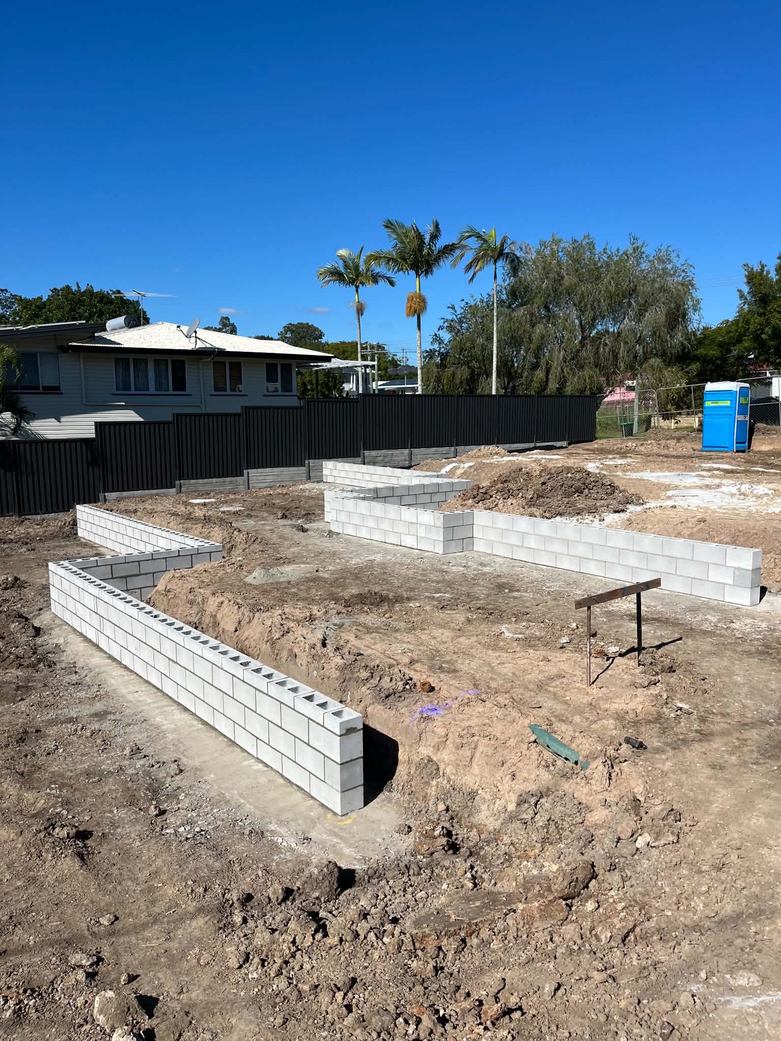 Tiered grey block retaining walls on a residential site during construction